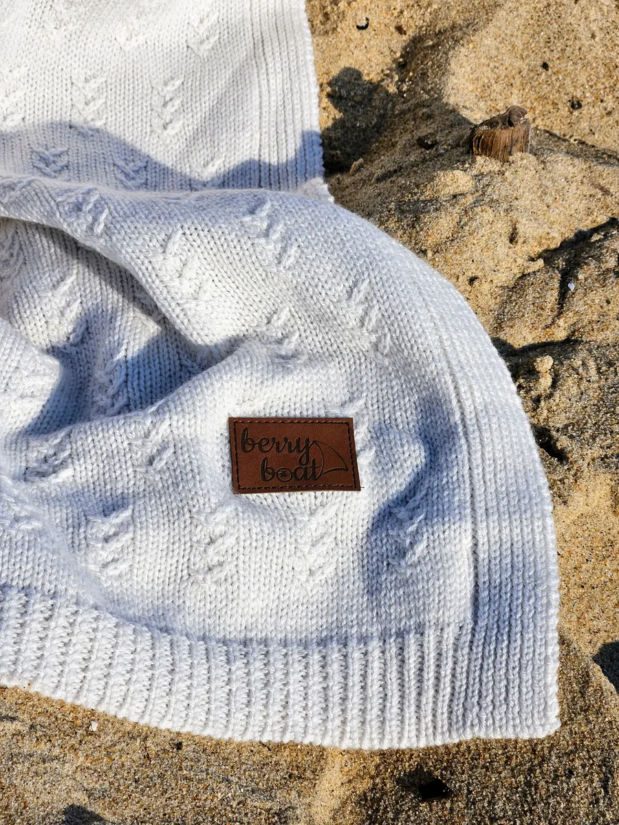 Leather patch: embossed logo on a knitted blanket — premium branding